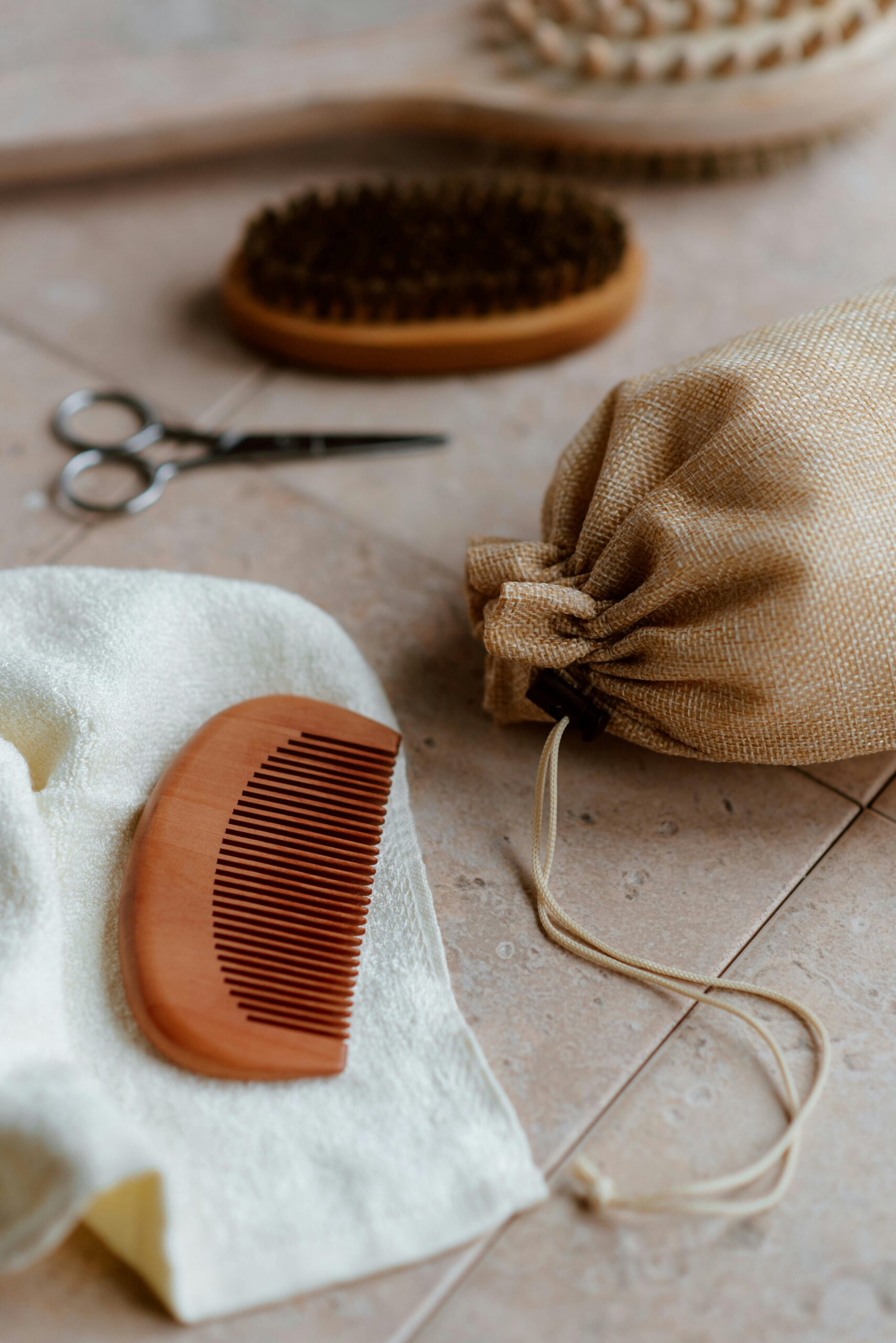 Fabric bag near wooden comb on tiled floor Fabric bag near wooden comb on tiled floor